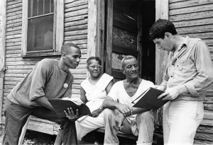 Johnny Waters, COFO block captain, Ceola Wallace and Jake Plum explains registration procedures to prospective voter Willie McGee in Hattiesburg, MS, 1964