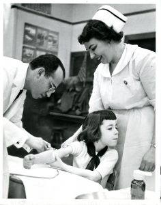 Dr. Jonas Salk inoculates Marlene Kohn as part of a polio vaccine field trial at a Pittsburgh elementary school.