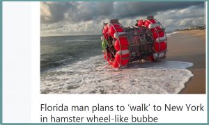 Man standing on surf inside of hamster-wheel like flotation device