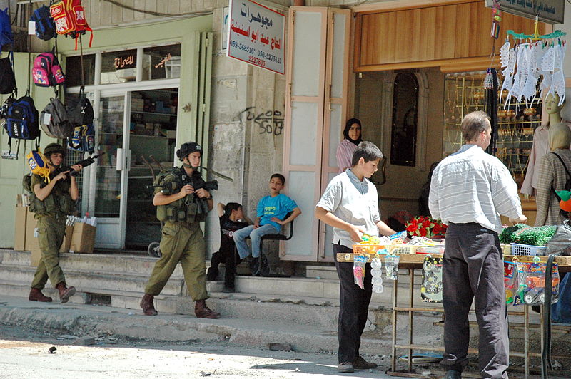 Israeli soldiers patrol a Palestinian open market