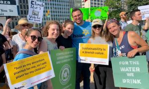 Hannah fine with five other organizers at a rally for the green new deal. Two hold signs that say "sustainability is a Jewish virtue"