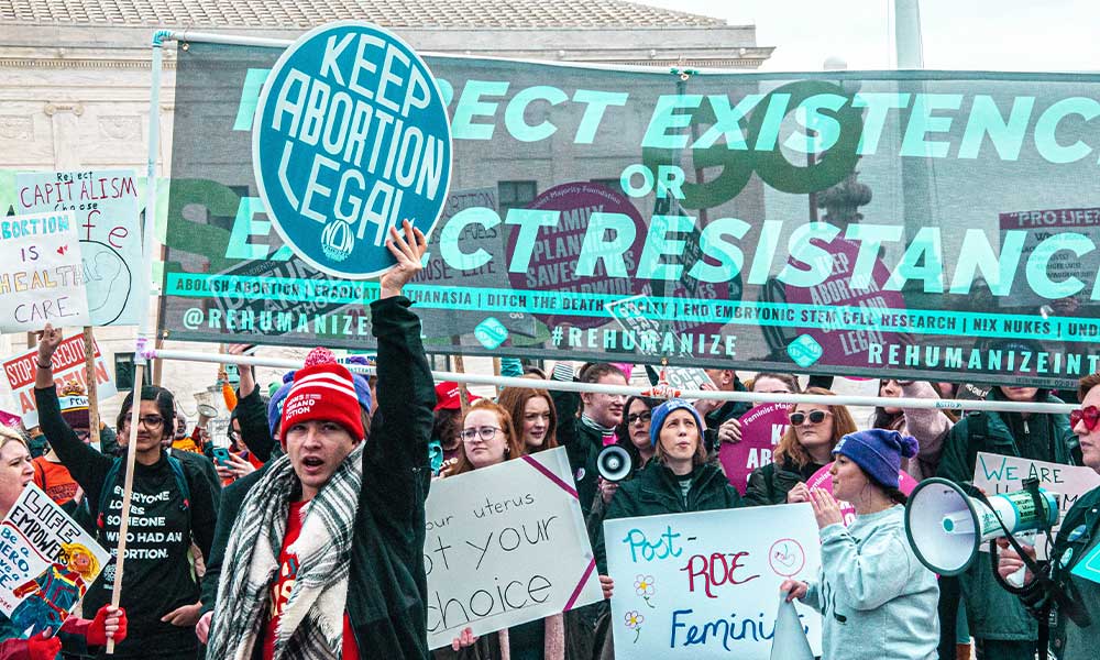 A pro-choice rally marches. Their signs that say things like "Keep abortion legal."