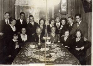 an old photo of a family sitting around a dinner table