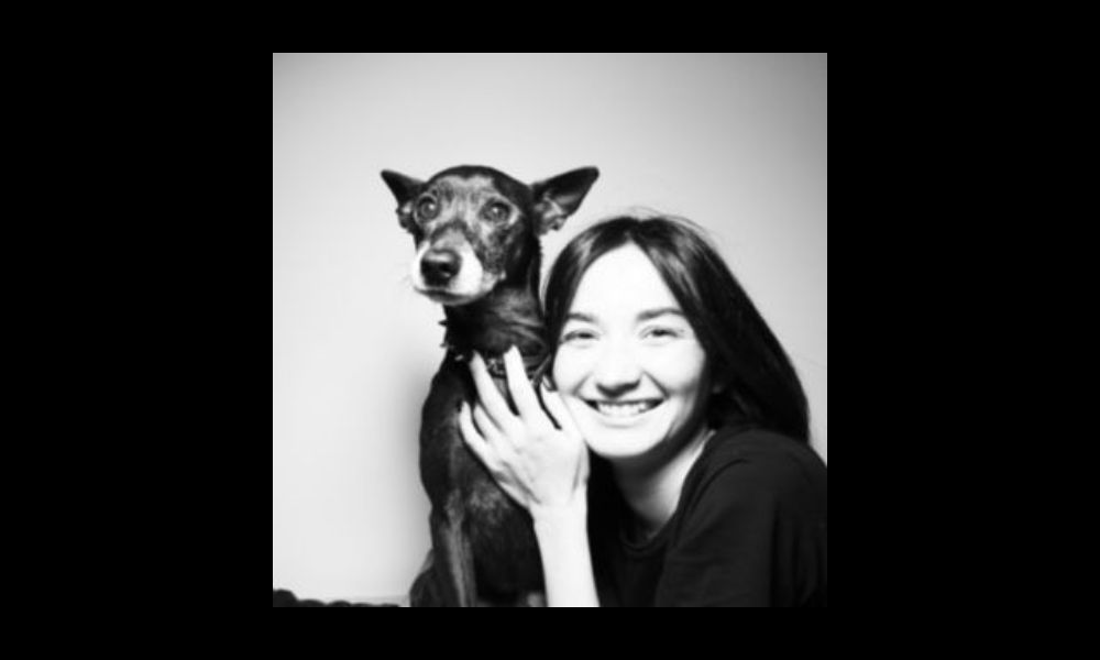 a woman poses with her dog
