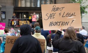 Protestors hold up signs demanding access to abortion