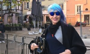 A woman with blue hair stands in Kyiv