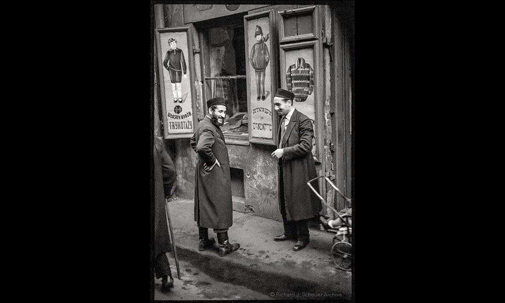 Historical photo of men in front of a Warsaw clothing store