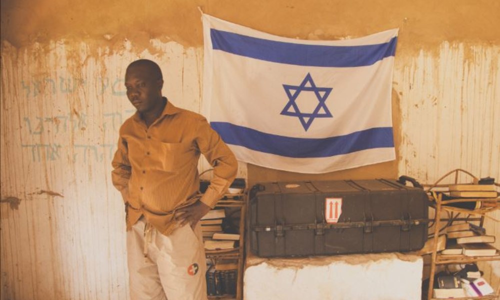 Shalom Putti standing next to Israeli flag