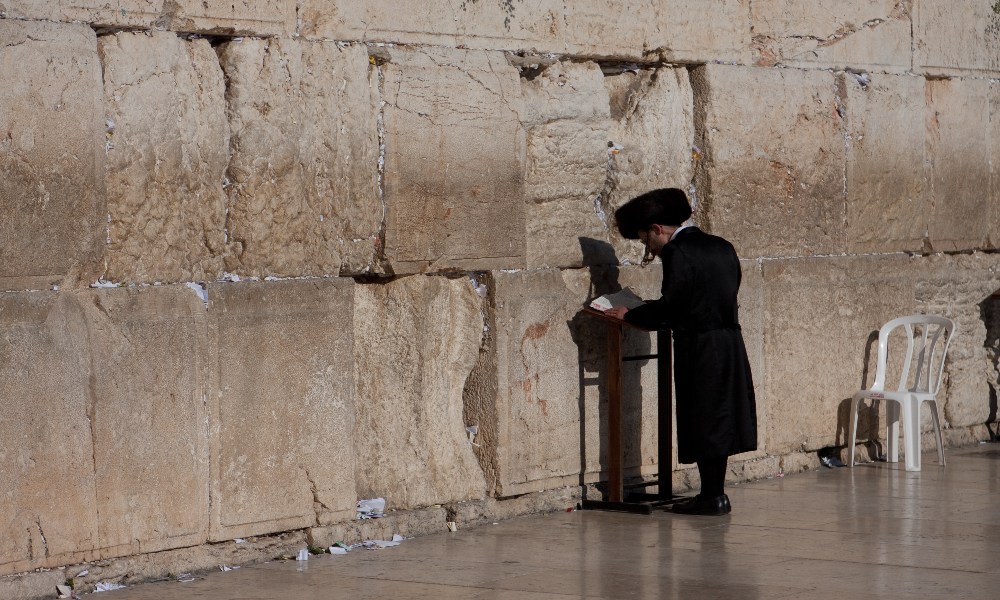 A man in the traditional dress of the Haredim prays at the Western Wall in Jerusalem.