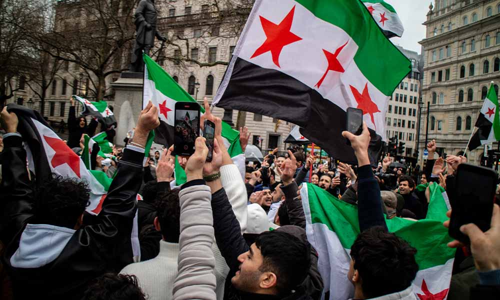 Syrian opposition supporters celebrate the fall of Damascus in Trafalgar Square, London, on December 8, 2024.